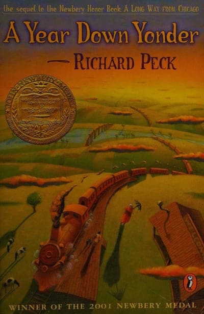 A warm gold-to-orange sunset landscape with a toy-like steam train curving through green fields, the title 'A Year Down Yonder' in tall gold script and 'RICHARD PECK' in black beneath it, a round gold Newbery Medal seal at left, and 'WINNER OF THE 2001 NEWBERY MEDAL' along the bottom.