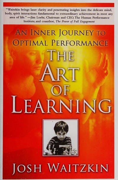 The Free Press paperback of The Art of Learning — a red-orange gradient field with a faded portrait silhouette and an open hand behind the title, a small black-and-white photo of young Josh Waitzkin at a chessboard, and his name in white block letters at the bottom.