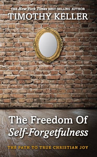 A 10Publishing edition of The Freedom of Self-Forgetfulness by Timothy Keller — an ornate gold-framed mirror hanging on a bare brick wall above a wood floor, the title in white and gold serif type below.