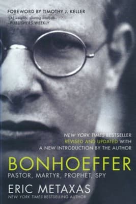 A black-and-white photograph of Dietrich Bonhoeffer's face filling the jacket, round wire-rim glasses, with 'BONHOEFFER' in yellow-green capitals across his chest and 'Pastor, Martyr, Prophet, Spy' in white beneath it, ERIC METAXAS in white capitals at the very bottom.