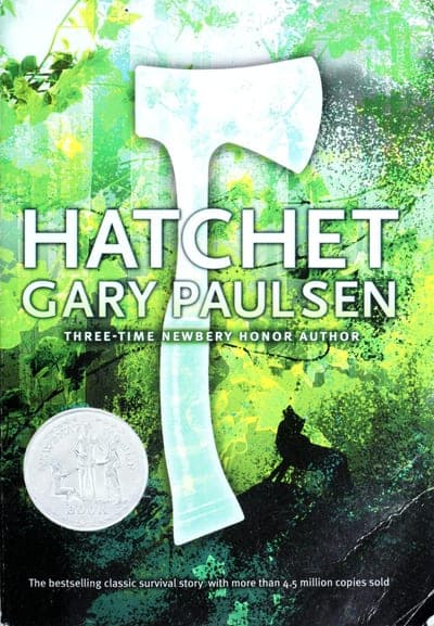 A green, paint-spattered paperback cover — a white hatchet silhouette rising through a leafy green explosion of color, 'HATCHET' in bold white capitals and 'GARY PAULSEN' beneath it, a silver Newbery Honor Book medallion at lower left, and a banner reading 'The bestselling classic survival story with more than 4.5 million copies sold.'