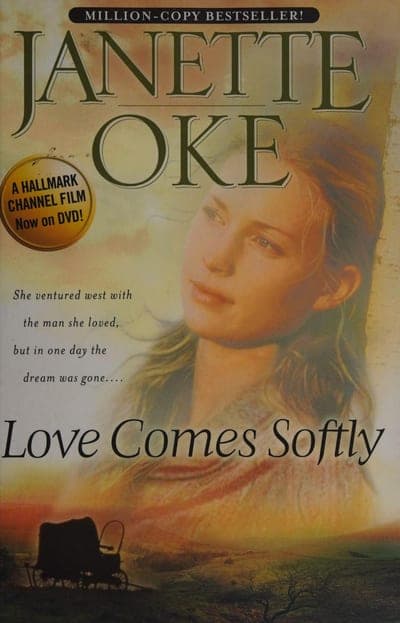 A sepia-toned field with a black 'MILLION-COPY BESTSELLER!' banner across the top, the author's name 'JANETTE OKE' in large dark green serif capitals, a gold seal reading 'A Hallmark Channel Film Now on DVD!', a painted portrait of a young woman looking over her shoulder, three lines of italic tagline copy, the title 'Love Comes Softly' in large green italic script, and a small silhouette of a covered wagon at the bottom edge.