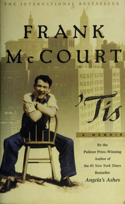 A paperback cover over a sepia-toned New York City skyline — 'THE INTERNATIONAL BESTSELLER' across the top, 'FRANK McCOURT' in large black serif capitals, a black-and-white photograph of a young man in overalls sitting backwards on a wooden chair, the title rendered in bold black script as "'Tis" with 'A MEMOIR' in a tan band beneath it, and cover copy reading 'By the Pulitzer Prize-Winning Author of the #1 New York Times Bestseller Angela's Ashes.'
